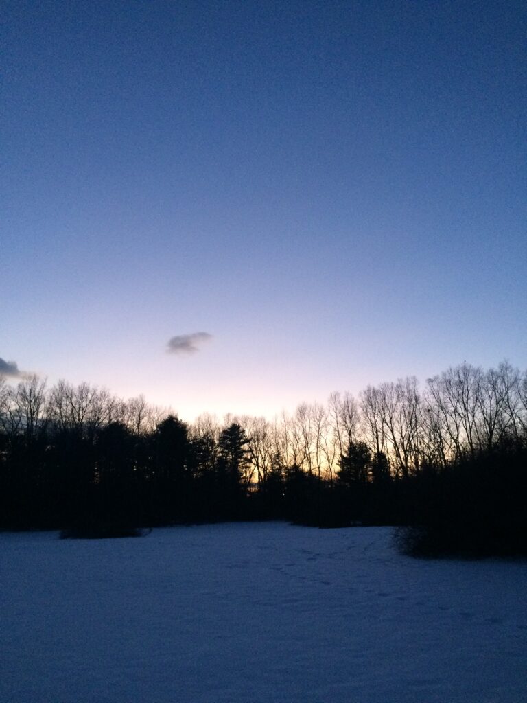 Sunset viewed across a snowy field